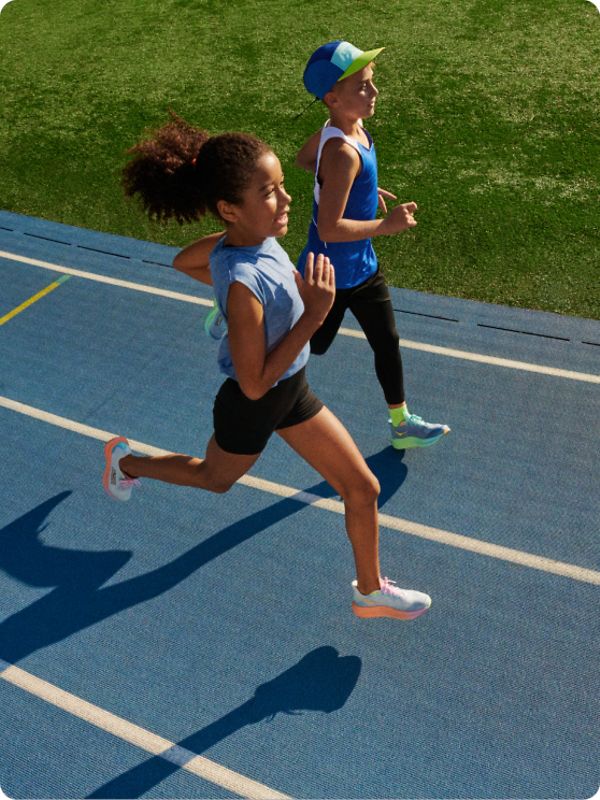 Kids running on a track wearing HOKA shoes.